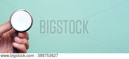 Female Hand Holds A Stethoscope On A Blue Background. Concept Doctor, Doctor's Appointment, Virus, T