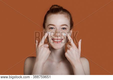 Close Up Photo Of A Ginger Lady With Freckles Appying Cream On Her Face Posing With Undressed Should