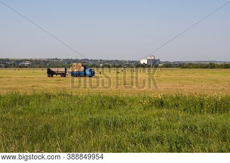 Nizhny Novgorod Region, Russia - July 8, 2020: Harvesting Hay, Agricultural Work In The Field Using 