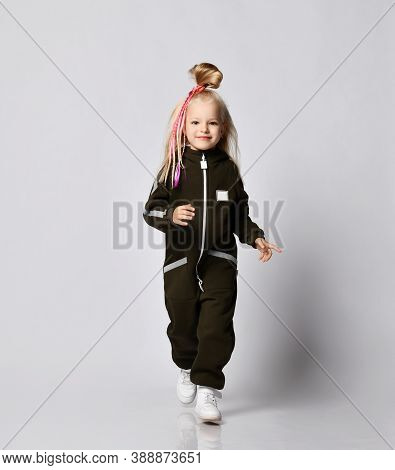 Sporty Blonde Kid Baby Girl With Stylish Hairstyle And Colorful Braids In Brown Comfortable Jumpsuit