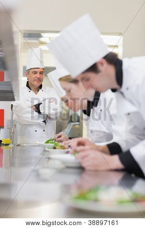 Kulinariska klass att göra sallader som lärare övervakar i kök