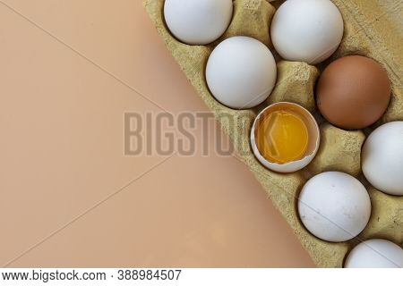 Chicken Eggs In An Egg Box And Egg Yolk. Copy Space. The Concept Of Natural Healthy Nutrition And Or