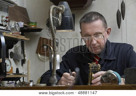 中年上老时钟在车间工作的修理工