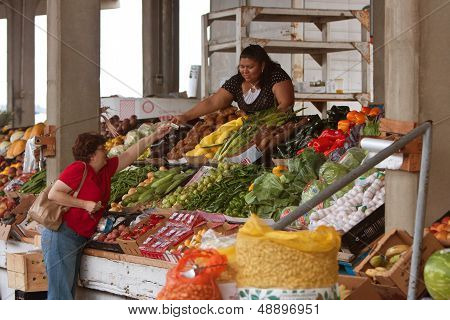Customer Pays For Fresh Produce At Farmers Market