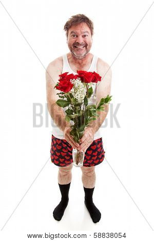 Humorous photo of a scruffy looking middle aged man in his underwear holding a bouquet of roses for his sweetie.  Full body isolated on white.  
