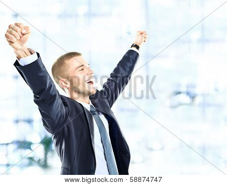 Successful man celebrating with arms up