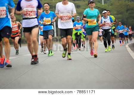 Unidentified marathon athletes legs running on city road