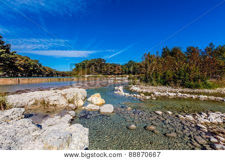 Blue Skies and Bright Beautiful Fall Foliage On The Crystal Clear Rocky Frio River in Texas