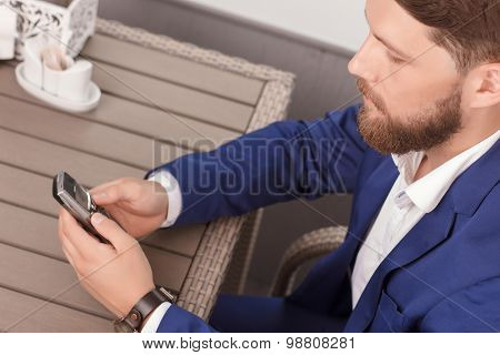 Handsome man using mobile phone in cafe
