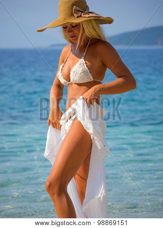 Youmg woman with sarong woman standing on the beach