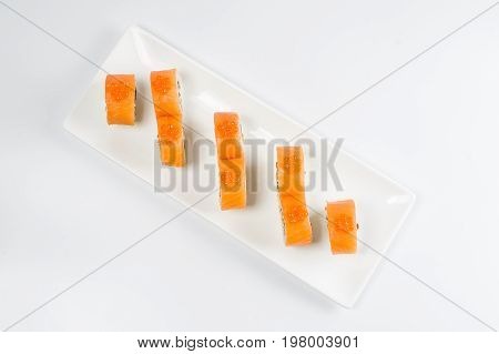 Sushi Rolls With Salmon, Avocado And Cream Cheese, Decorated With Red Caviar, Served On White Slate.