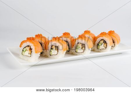Sushi Rolls With Salmon, Avocado And Cream Cheese, Decorated With Red Caviar, Served On White Slate.