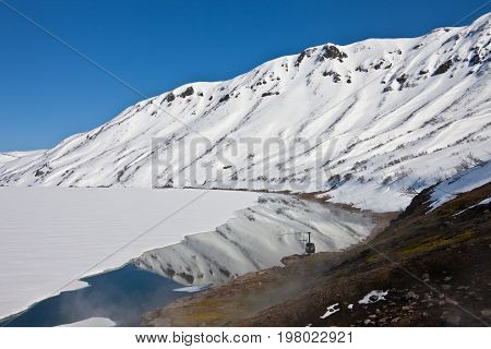 Helicopter from the hot springs on the shore of Karymsky lake in spring in Kamchatka Russia
