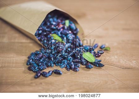 Fresh Honeysuckle Blue Berry Fruits With Leaf On A Wooden Background
