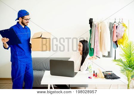 Woman accepting a box package from deliveryman