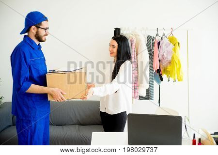 Woman accepting a box package from deliveryman