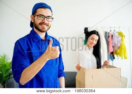 A portrait of a smiling deliveryman showing thumbs up