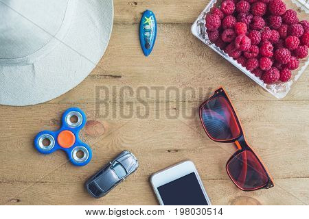 Summer Holiday, Vacation, Relaxation Concept. Raspberries, Hat, Smartphone, Spinner, Sunglasses From