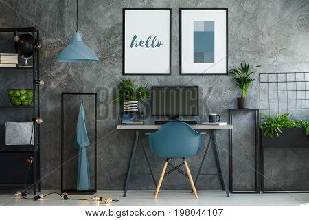Stylish turquoise and gray interior with desk and mock-up posters