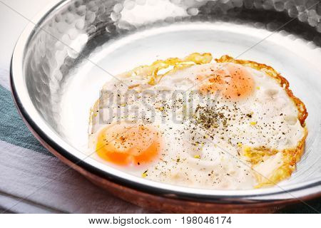 Pan with over hard fried eggs, closeup