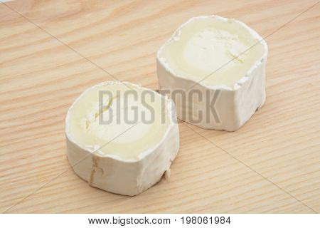 Goat Cheese on wood background, brown color