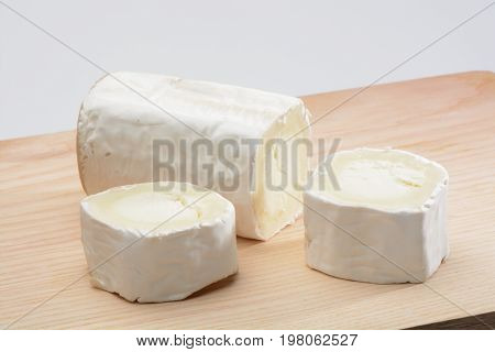 Goat cheese on wood background, brown color