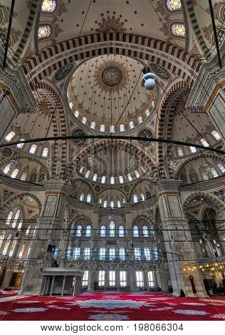 Istanbul Turkey - April 25 2017: Interior of Fatih Mosque a public Ottoman mosque in Fatih district with a huge decorated domes & many colored stained glass windows