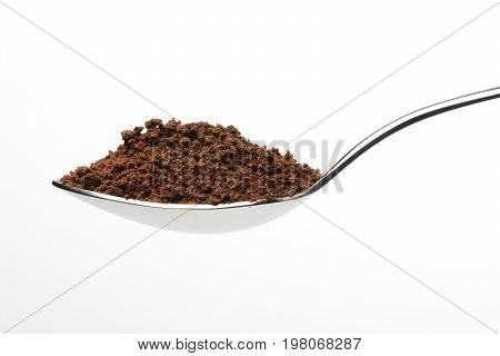 Soluble coffee on white background in a spoon