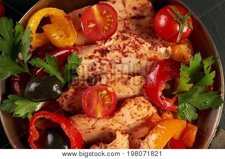 Fried chicken with vegetables on the pan and Italian pasta with a parmesan cheese basil olives paprica and tomatoes on a plate. Healthy food copncept. Top view copy space.