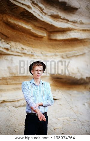 Stylish Attractive Man Stands In The Middle Of A Sand Quarry And Poses On The Camera