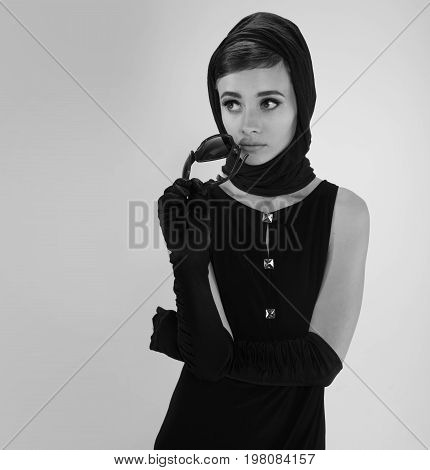 beautiful young woman in retro style with sunglasses and a head scarf black and white photography