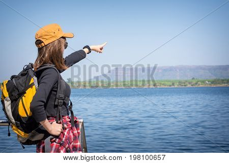 Tourist Young Woman Finger Pointing To The Mountain. Tourism Concept.