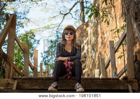 Tourist Young Woman Wearing Hat Enjoying Sitting On The Stairs Mountain.