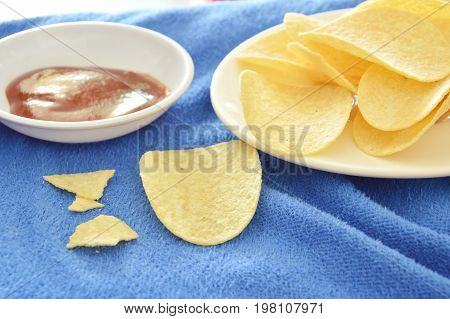 crispy and salt potato chips on dish dipping with ketchup