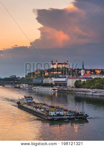 Cityscape of Bratislava Slovakia at Sunset as Seen from a Bridge over Danube River with a Ship towards Btatislava Castle