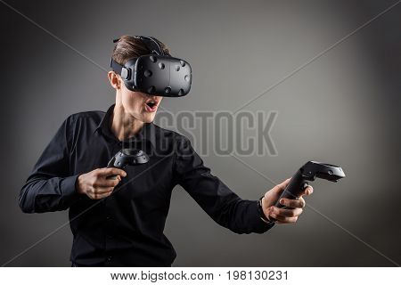 Technology, Gaming, Entertainment And People Concept - Happy Young Man With Virtual Reality Headset