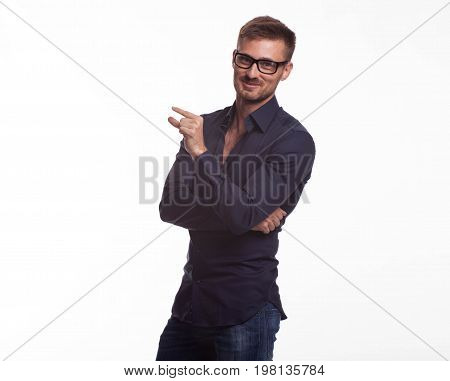 Young jocular man portrait of a confident businessman showing by hands on a gray background. Ideal for banners, registration forms, presentation, landings, presenting concept.