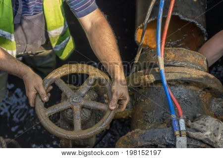 Industrial Worker Turning A Valve On A Large Pipe 2