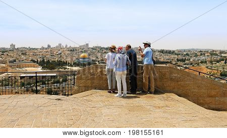 Jerusalem, Israel - May 25, 2017: The guide shows the Jerusalem Old City view to the tourists and pilgrims. Mount of Olives is a famous Holy Land place and it has a fantastic view to the Old Jerusalem