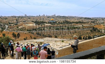 Jerusalem, Israel - May 25, 2017: The guide shows the Jerusalem Old City view to the tourists and pilgrims. Mount of Olives is a famous Holy Land place and it has a fantastic view to the Old Jerusalem