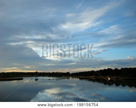 Clouds reflecting off tranquil Mattapoisett River near dawn
