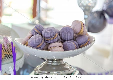 Wedding macaroni purple on a plate. Sweet table