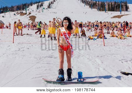 Young Happy Pretty Women On A Snowboard In Colorful Bikini.