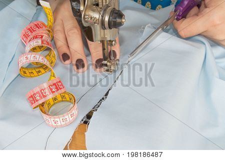 Woman hand on sewing machine.Dressmaker work on the sewing machine. Hobby sewing fabric as a small business concept. Female tailor threading leather material on sewing machine