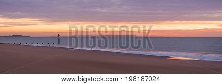 The sun rises over the sea at Bournemouth illuminating the cloads and the sea