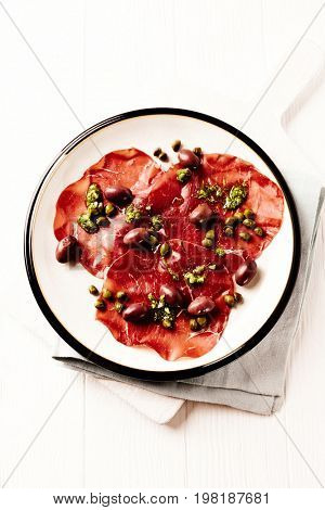 Bresaola (beef carpaccio) with olives and capers