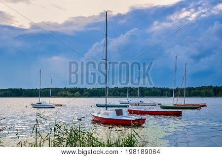 Summer evening landscape. Boats on the lake and colorful sky.