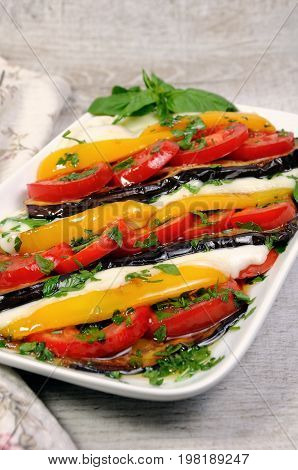 Baked eggplants with tomatoes yellow pepper and slices mozzarella
