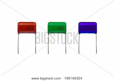 Mylar polyester capacitors with a brown and a green and a blue color isolated on white background. electronics part concept.