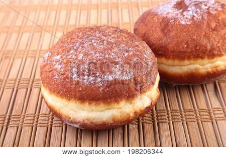 Homemade Doughnuts with Jelly filled and powdered sugar on Bamboo tablecloth. Selective focus